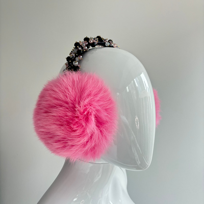 Pink earmuffs featuring luxurious jeweled embellishments on the headband, with soft, fluffy ear coverings for warmth and a glamorous winter look.